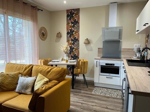 une cuisine et un salon avec un canapé et une table dans l'établissement Gîte de Charme pour 2 pers. dans le Périgord Noir, à Veyrines-de-Domme
