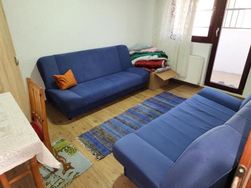 um sofá azul sentado numa sala de estar em Sarajevo Garden BBQ Villa with Parking em Vogošća