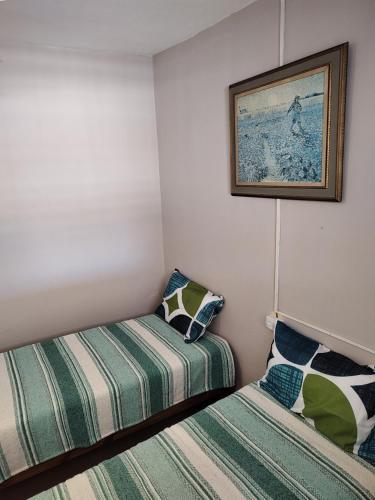 ミナ・クラベロにあるLa Mora Departamentoのベッド2台が備わる部屋、壁に絵が飾られた部屋