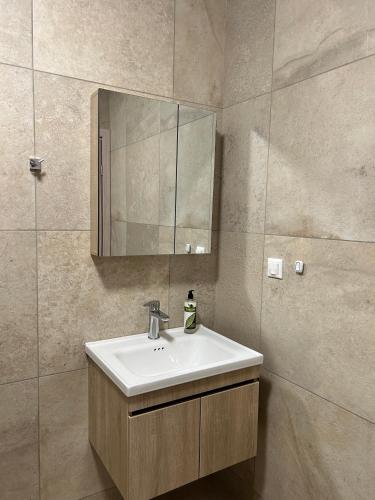 a bathroom with a sink and a mirror at TEGEA LUXURY SUITES Aphrodite in Tripoli