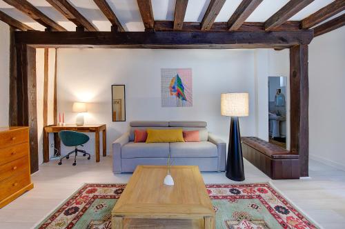 een woonkamer met een blauwe bank en een tafel bij Chic et Cosy - Hyper Centre - Arrivée Autonome in Tours