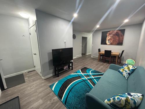 a living room with a blue couch and a television at Cute Highland Park Entire Unit A in Calgary