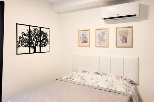 um quarto com uma cama e três fotografias na parede em Nosso Apê 915: Ar-condicionado | Piscina | Academia - NA1302 em Juiz de Fora