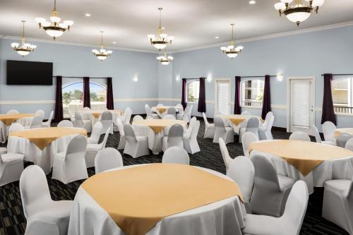 a room with tables and chairs and a flat screen tv at La Copa Inn Beach Hotel in South Padre Island