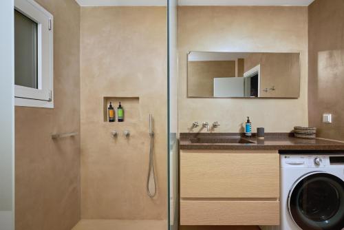 a bathroom with a shower with a sink and a washing machine at Crete - Heraklion Sea View Apartment 1 in Heraklio Town