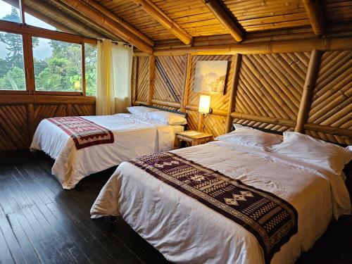 1 dormitorio con 2 camas en una habitación de madera en GOLDEN TREE MINDO ECO-LODGE, en Mindo