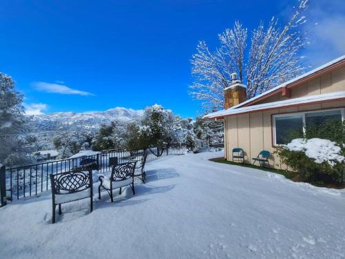 a group of benches in the snow next to a building at Rustic Yosemite Cottage-King Suite-Mountain Views in Oakhurst