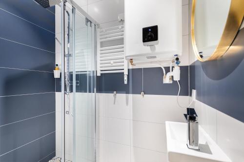 une salle de bain avec douche et lavabo dans l'établissement Guestrust - Arc de Triomphe Green, à Paris