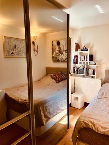 une chambre avec un lit superposé et un miroir dans l'établissement Jolie 2 pièces avec balcon Paris 15 Eme, à Paris