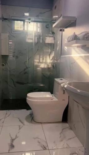 a white bathroom with a toilet and a sink at Casa Chavez en Tela in Tela