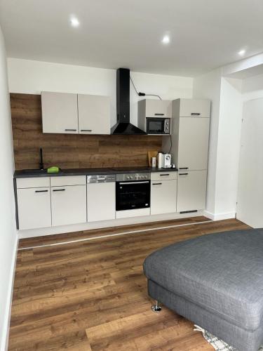 una cocina con armarios blancos y una cama en una habitación en Apartment Deluxe Rosenheim Top 2 