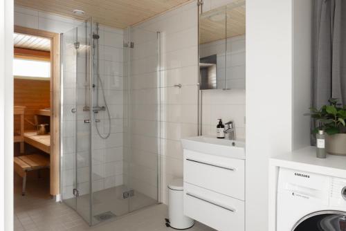 y baño con ducha y lavamanos. en Stunning design apartment with sauna & free parking, en Helsinki