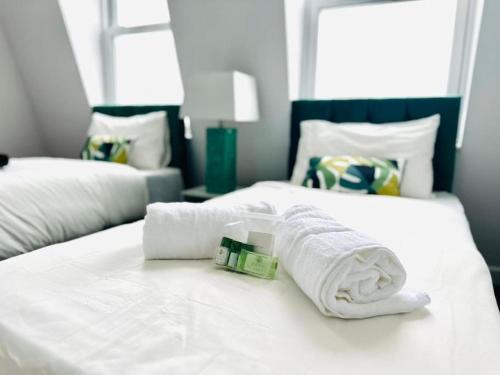 a hotel room with two beds with towels on them at Seaview apartment in Kent in Kent