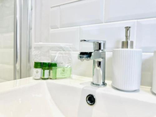 a bathroom sink with a faucet and two bottles at Seaview apartment in Kent in Kent