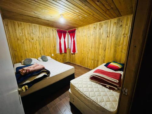 リナレスにあるCabaña en linares camino el embalse ancoaのベッド2台と窓が備わる小さな客室です。