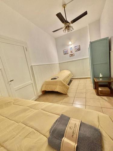 1 dormitorio con 2 camas y ventilador de techo en Casa Blanca 2 en Santiago del Estero