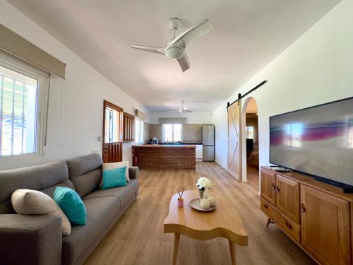 sala de estar con sofá y TV de pantalla plana en Casa de campo Sierra Gorda, en Málaga
