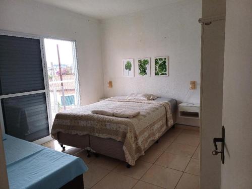a bedroom with a large bed and a window at Sobrado charmoso em localização central! in Sorocaba