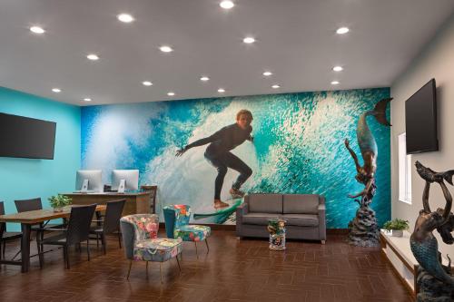 a room with a painting of a surfer riding a wave at La Copa Inn Beach Hotel in South Padre Island