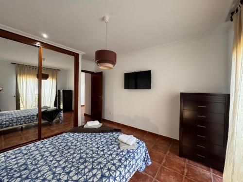 um quarto com uma cama, uma cómoda e um espelho em Alquilaencanarias Sotavento Paradise em Granadilla de Abona