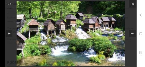 a group of wooden huts next to a river at Rose Apartmans in Jajce