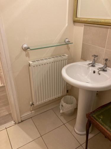 a bathroom with a sink and a radiator at Jacks Court B2 in Stalybridge