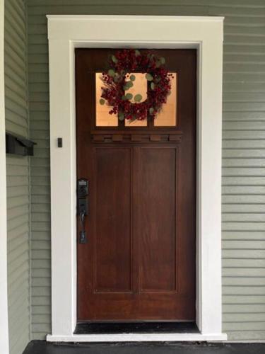 a wooden door with a wreath on top of it at Newly remodeled bungalow near downtown Brenham in Brenham