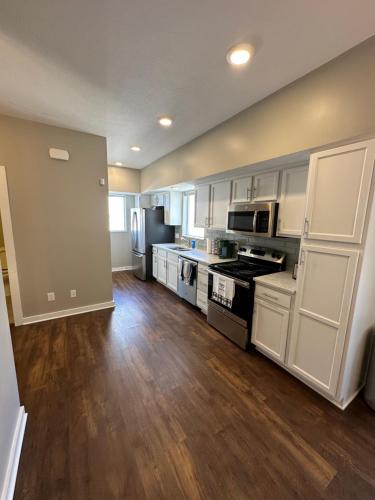 a large kitchen with white appliances and wooden floors at Luxury Downtown Townhome Unit 13 in Cleveland