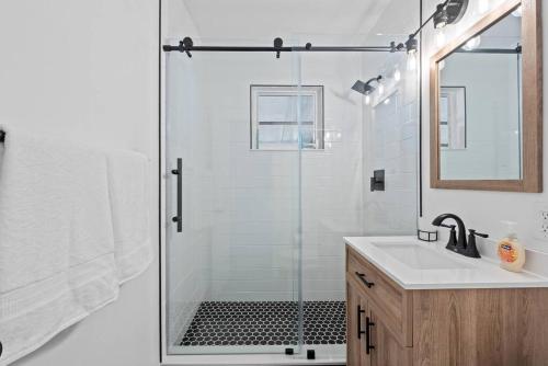 a bathroom with a shower with a sink and a mirror at Comfy BNB #2 King Bed + Work/Travel + Beach 8 Min in Hallandale Beach
