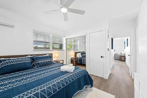 a bedroom with a blue bed and a ceiling fan at Comfy BNB #2 King Bed + Work/Travel + Beach 8 Min in Hallandale Beach