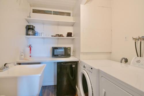 a white kitchen with a washer and dryer at Oceanview Home with Hot Tub, Fenced Yard, and Dog-Friendly in Lincoln City