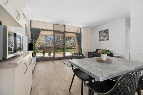 a kitchen and dining room with a table and chairs at Riversands Rest Accommodation Scenic Riverfront Cottages, Paringa in Renmark