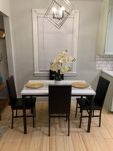 a dining room table with chairs and a vase of flowers at Be our guest BOHO 2.0 in Charlotte