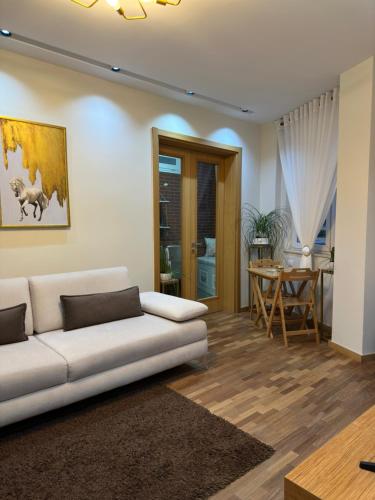 un soggiorno con divano bianco e tavolo di Dry Lake Apartment a Tirana
