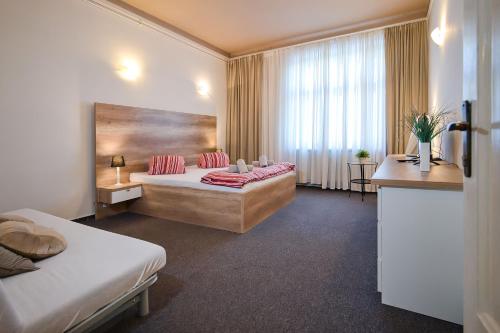 a hotel room with two beds and a window at Stodolní Apartment in Ostrava