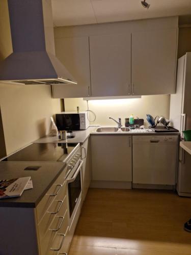 a kitchen with white cabinets and a stove top oven at God søvn in Lillestrøm