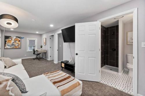 a living room with a white couch and a shower at A Home Away from Home! in Chicago