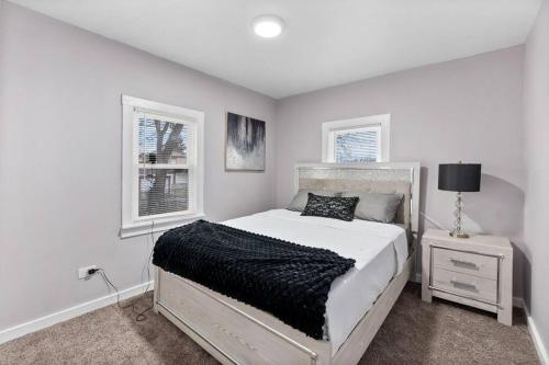 a white bedroom with a bed and two windows at A Home Away from Home! in Chicago