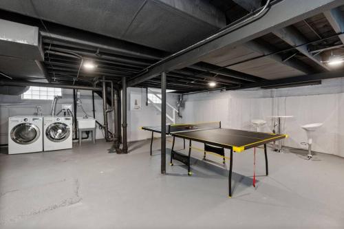 a room with a ping pong table and washing machines at A Home Away from Home! in Chicago