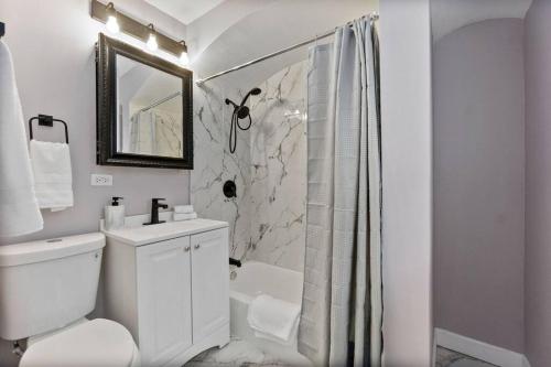 a white bathroom with a toilet and a shower at A Home Away from Home! in Chicago
