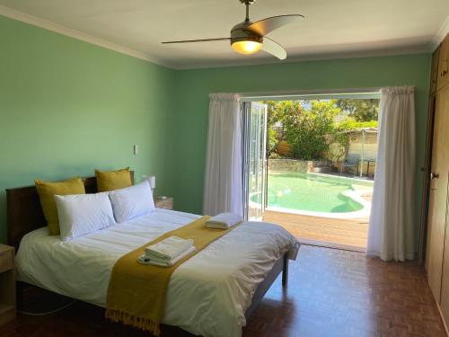 a bedroom with a bed and a window with a pool at Doordrift Extension in Cape Town