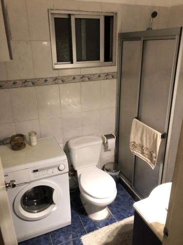 a bathroom with a toilet and a washing machine at Departamento Pocitos con anfitrión in Montevideo