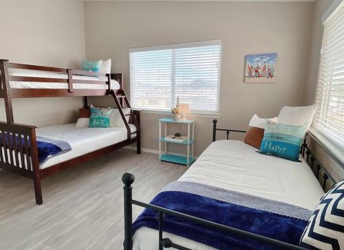 a bedroom with two bunk beds and two windows at Multi Family! 2 min walk to Beach! EV Charger! in Oceano