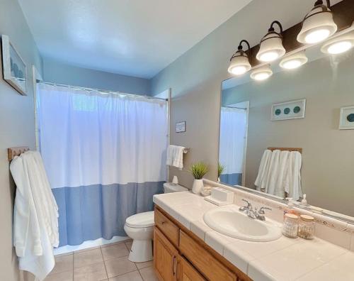 a bathroom with a sink and a toilet and a mirror at Multi Family! 2 min walk to Beach! EV Charger! in Oceano