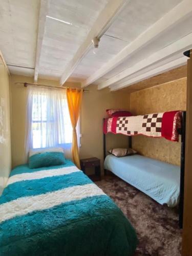 1 dormitorio con 2 camas y ventana en Hospedaje Marisol, en Pichicolo