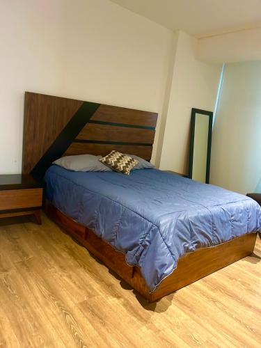 1 dormitorio con 1 cama grande y cabecero de madera en Departamento en zona real a 5 mins de Andares, en Guadalajara
