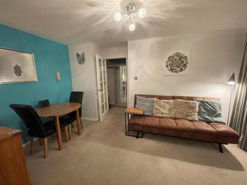 a living room with a couch and a table at Beautiful Peaceful Studio Flat in Waltham Abbey