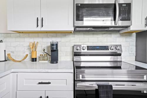 a kitchen with a stove and a microwave at Recently Remodeled Mins from beach+Putting Green in Boynton Beach