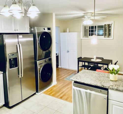 a kitchen with a stainless steel refrigerator and a table at North Bethesda Gem in Rockville