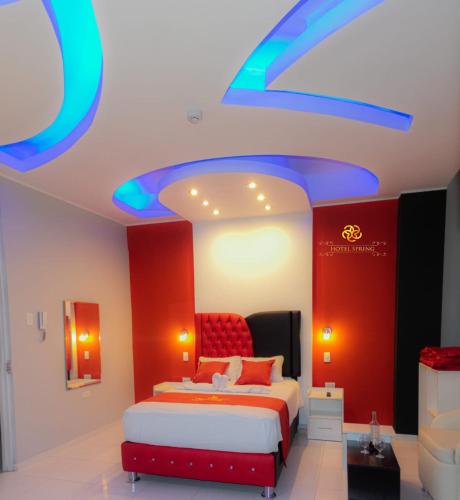 a bedroom with a red and blue ceiling at Hotel Spring in Huánuco